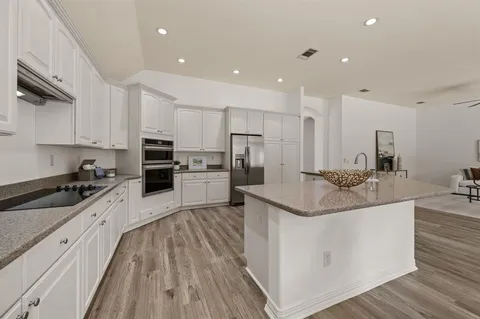 a large kitchen with stainless steel appliances granite countertop a sink stove and refrigerator