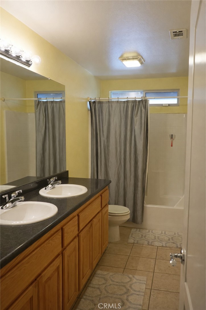 19095 Glenwood Avenue Riverside, CA 92508 - Photo 8 of 14 a bathroom with a sink a toilet a mirror and shower