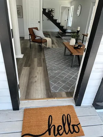 a living room with chairs and a rug