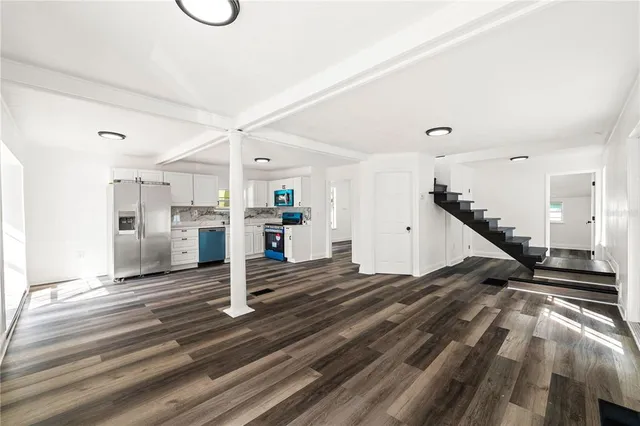 a view of a hallway with wooden floor and staircase