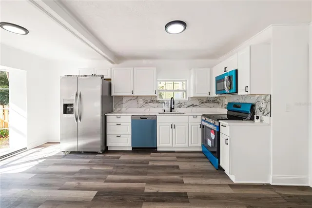 a kitchen with a refrigerator sink and cabinets