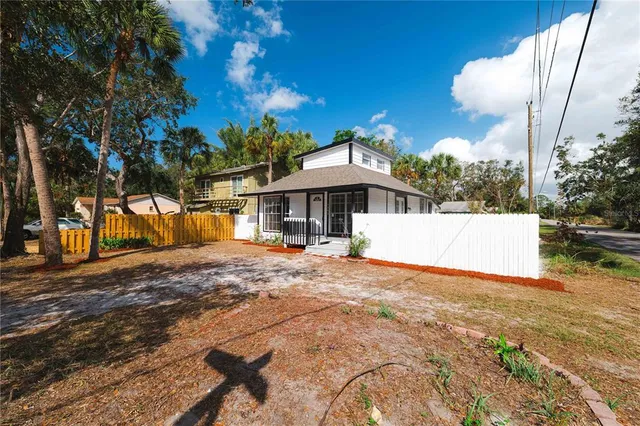 a view of a house with backyard and a tree