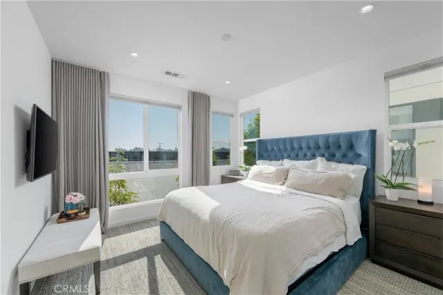 a bedroom with a large bed and a flat screen tv