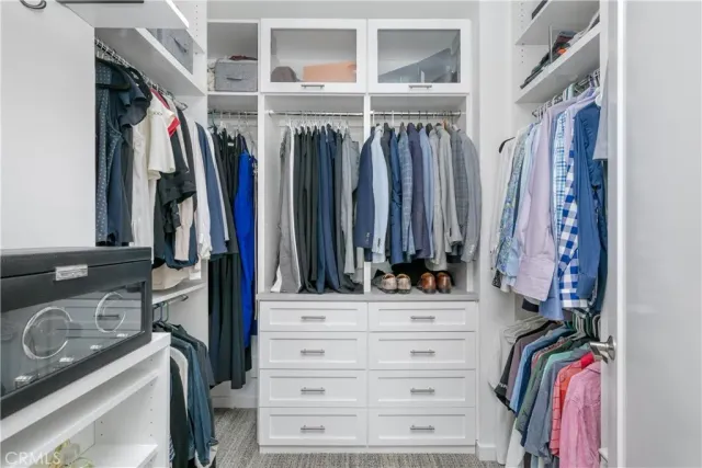 a view of walk in closet with clothes and shoes