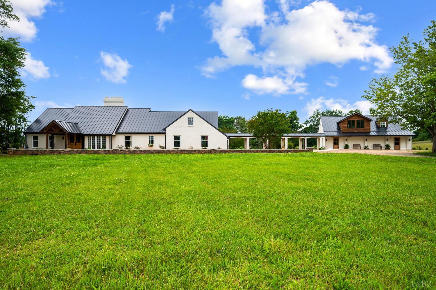 a view of a house with a small yard and sitting area