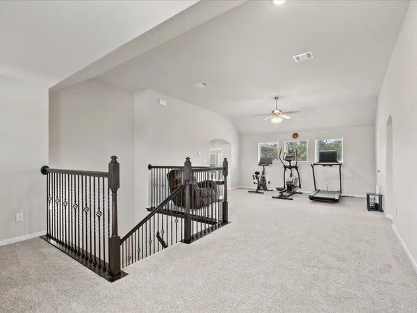 a open kitchen with stainless steel appliances granite countertop a stove top oven a refrigerator a dining table and chairs with wooden floor
