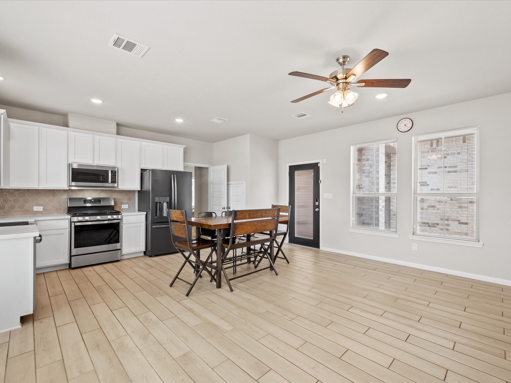 262 Peninsula Point Drive Montgomery, TX 77356 - Photo 31 of 45 a open kitchen with stainless steel appliances granite countertop a stove top oven a refrigerator a dining table and chairs with wooden floor