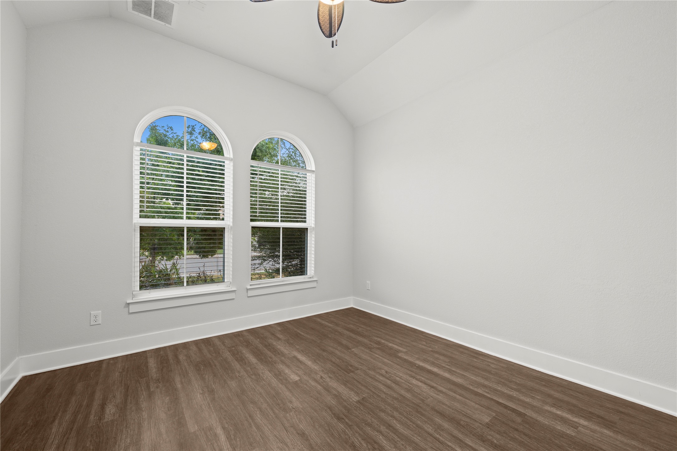 60 Rancho Trail Georgetown, TX 78628 - Photo 20 of 36 Vaulted ceilings and arched windows create an airy feel over wood-style flooring.
