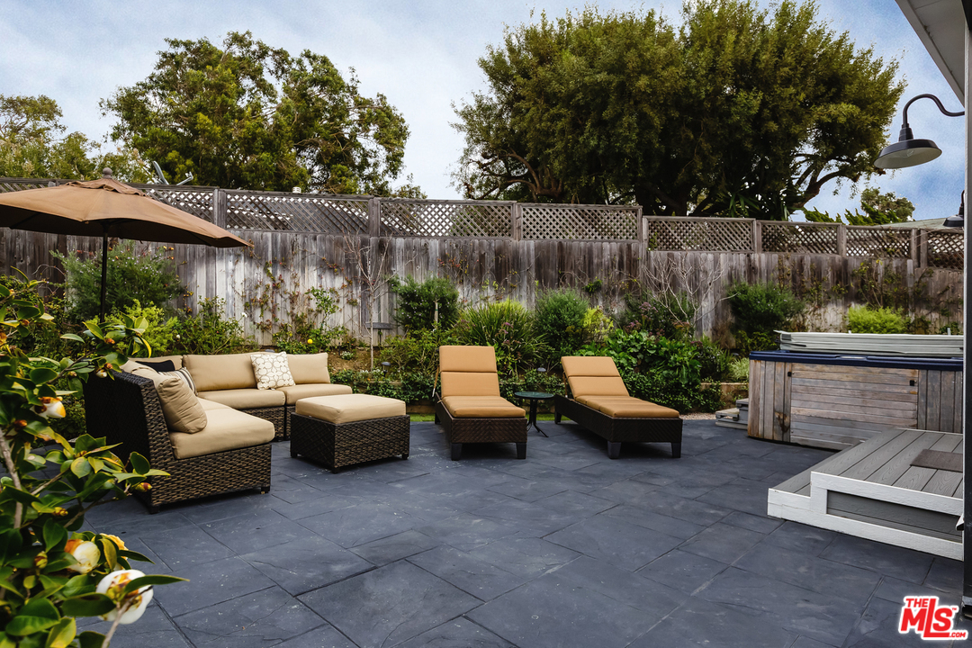 248 Paradise Cove Road Malibu, CA 90265 - Photo 25 of 35 a view of a patio with couches and a table and chairs with wooden fence