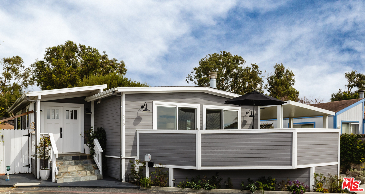 248 Paradise Cove Road Malibu, CA 90265 - Photo 6 of 35 a view of a white house with large windows and a small yard