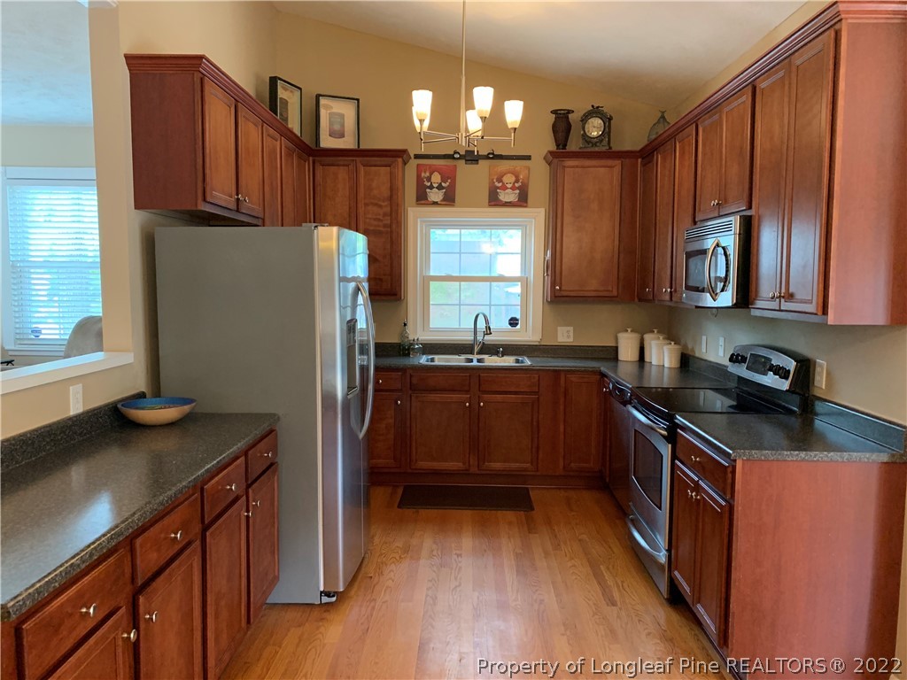 3629 Drayton Road Fayetteville, NC 28303 - Photo 11 of 31 a kitchen with granite countertop a refrigerator stove top oven and sink