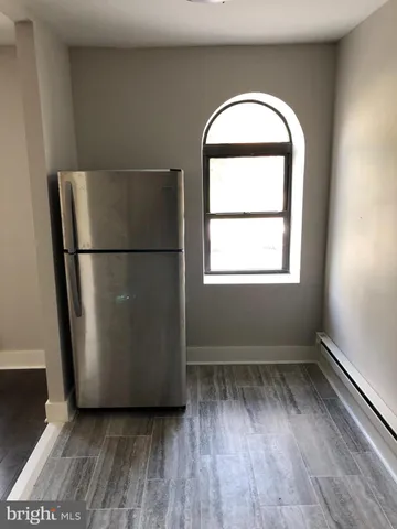 a view of a room with wooden floor and a small space