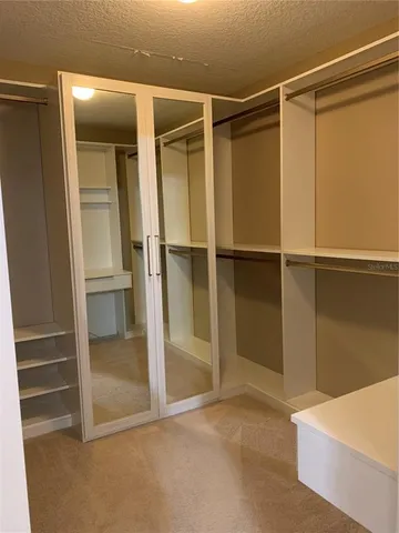 a view of walk in closet with empty racks