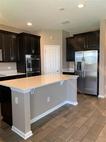 a kitchen with stainless steel appliances granite countertop a sink counter space cabinets and a large window
