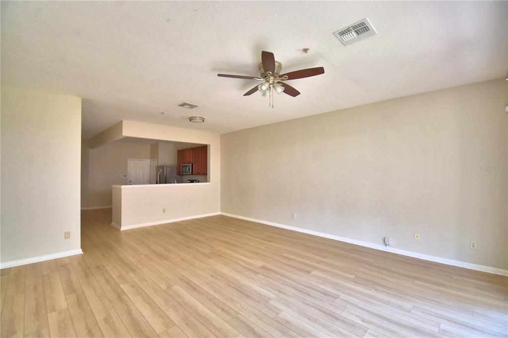 3151 Sinclair Street, Unit 104 Orlando, FL 32835 - Photo 13 of 64 a view of empty room with wooden floor and ceiling fan