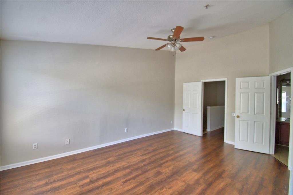 3151 Sinclair Street, Unit 104 Orlando, FL 32835 - Photo 25 of 64 a view of a room with wooden floor and a ceiling fan