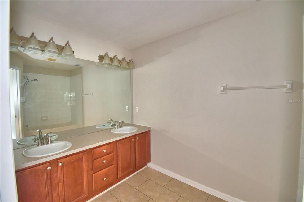 3151 Sinclair Street, Unit 104 Orlando, FL 32835 - Photo 26 of 64 a spacious bathroom with a granite countertop sink mirror and double