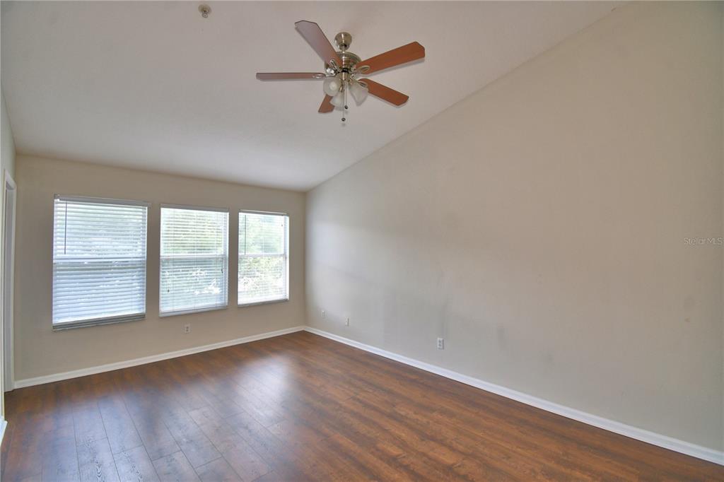 3151 Sinclair Street, Unit 104 Orlando, FL 32835 - Photo 29 of 64 an empty room with wooden floor fan and windows