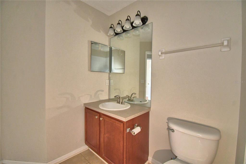3151 Sinclair Street, Unit 104 Orlando, FL 32835 - Photo 39 of 64 a bathroom with a toilet sink and mirror