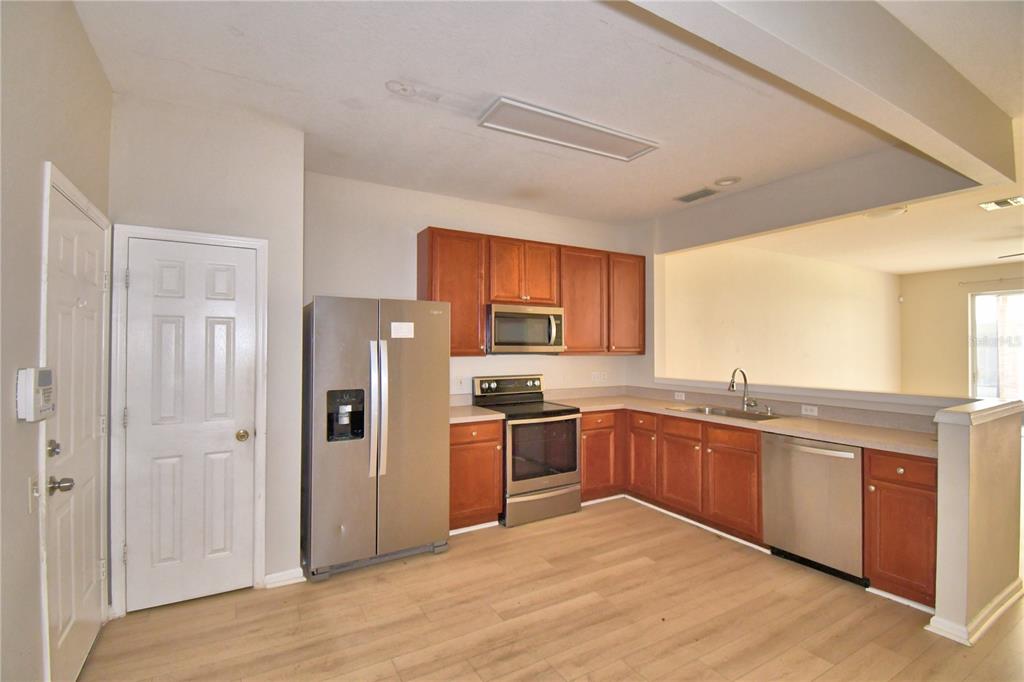 3151 Sinclair Street, Unit 104 Orlando, FL 32835 - Photo 4 of 64 a kitchen with stainless steel appliances granite countertop a stove top oven a refrigerator and a sink