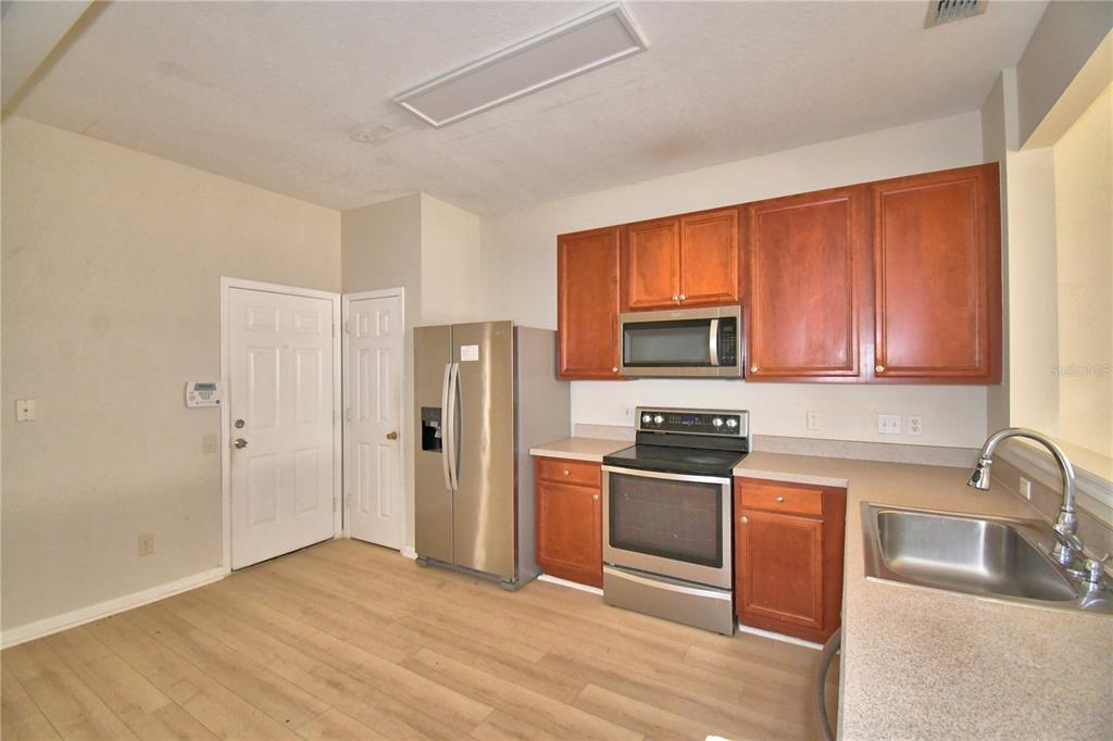 3151 Sinclair Street, Unit 104 Orlando, FL 32835 - Photo 5 of 64 a kitchen with stainless steel appliances granite countertop a refrigerator stove and sink