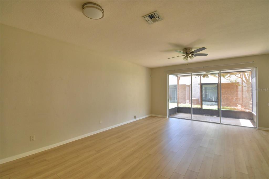 3151 Sinclair Street, Unit 104 Orlando, FL 32835 - Photo 9 of 64 an empty room with wooden floor and windows