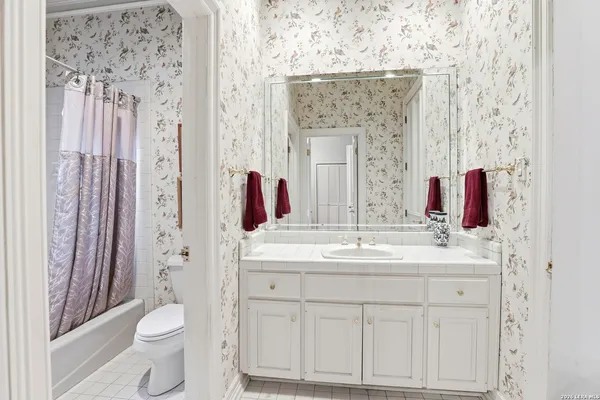 a bathroom with a sink vanity mirror and toilet