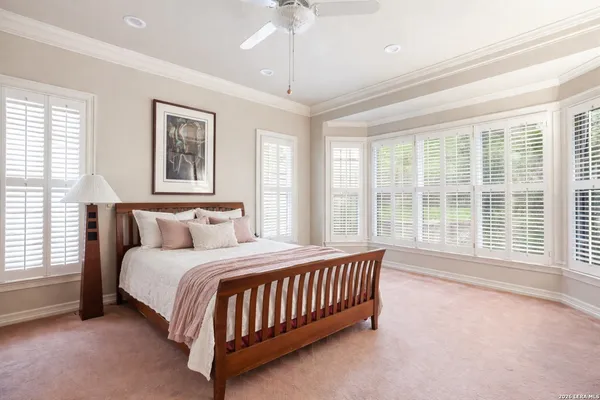 a bedroom with a large bed and a chandelier