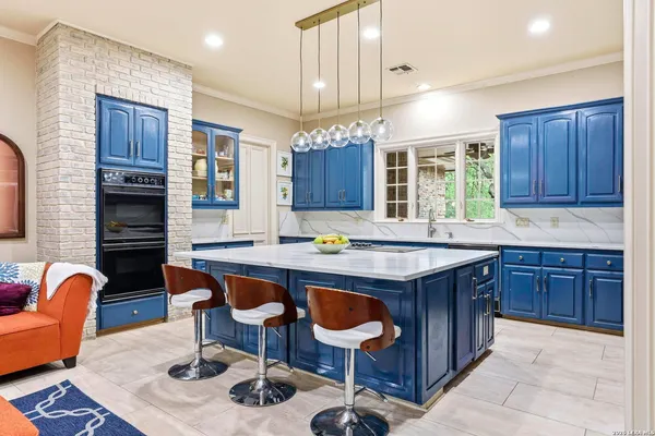 a kitchen with granite countertop a table chairs stove a refrigerator and cabinets