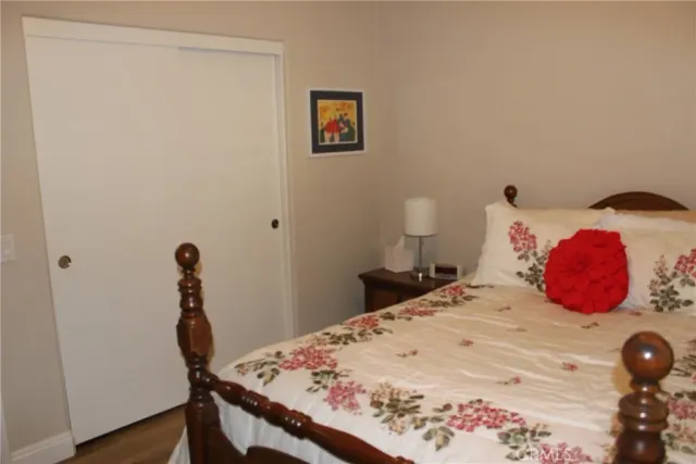 a bedroom with a bed and a wooden floor