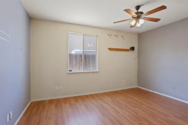 a view of a room with wooden floor and a ceiling fan