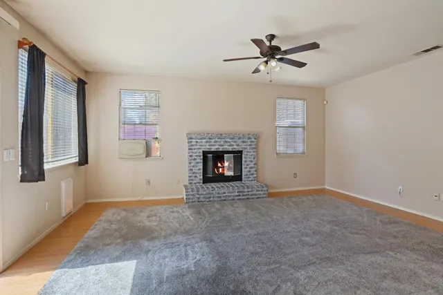a view of an empty room with a fireplace and a window