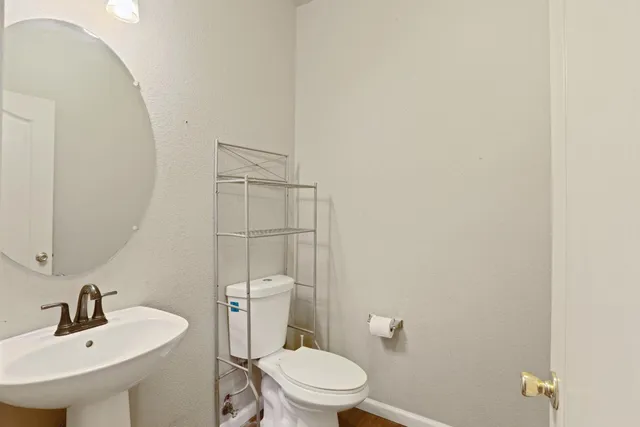 a bathroom with a toilet a sink and mirror