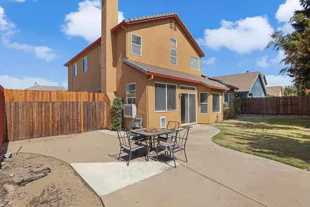 a view of a house with backyard and sitting area