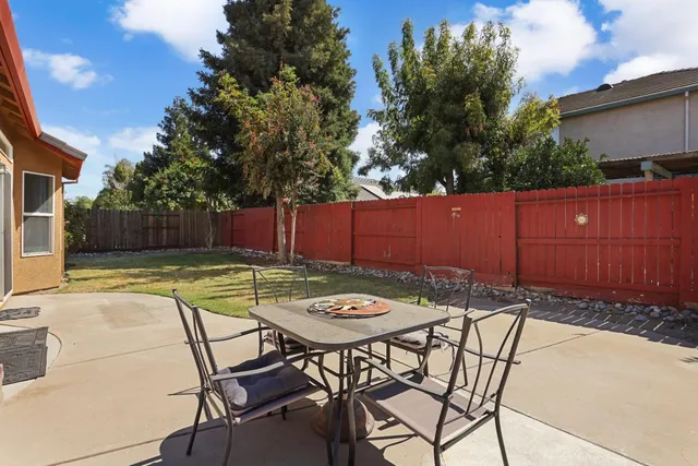 a view of a backyard with swimming pool and sitting area