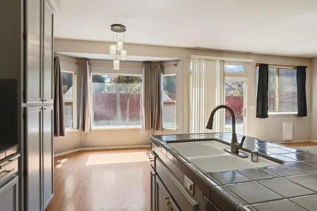 a kitchen with granite countertop a sink and chandelier