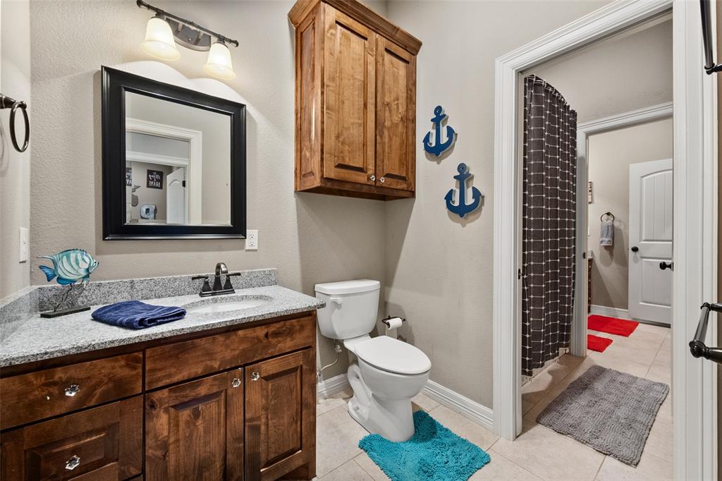 606 Sunset Point Kerens, TX 75144 - Photo 15 of 39 a bathroom with a toilet a sink and a mirror