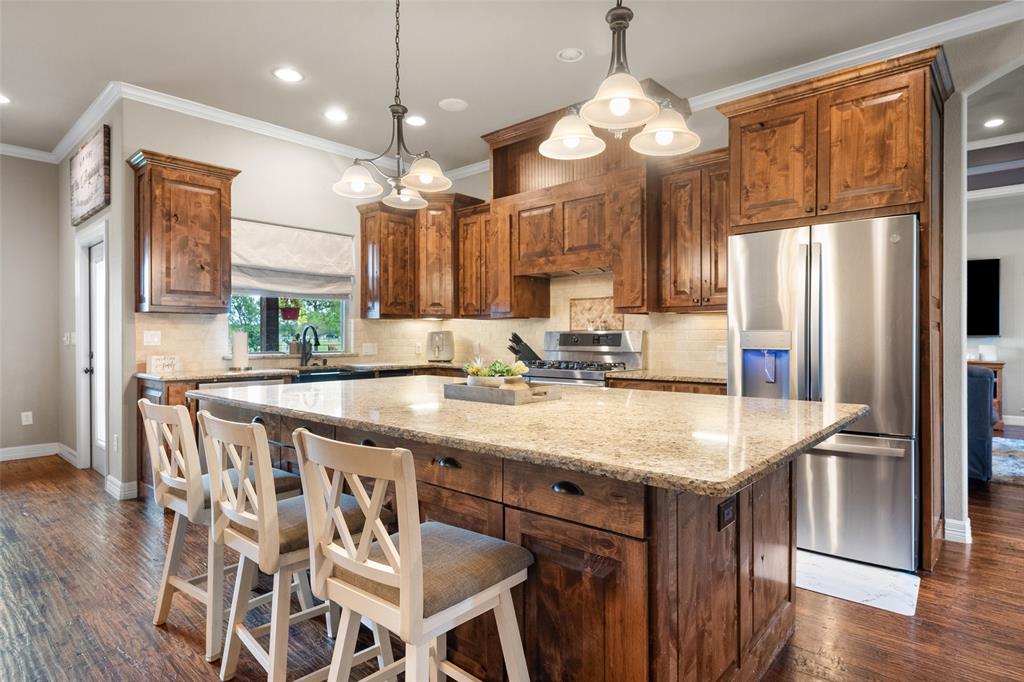 606 Sunset Point Kerens, TX 75144 - Photo 8 of 39 a kitchen with kitchen island granite countertop a sink a center island and stainless steel appliances