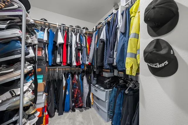 a view of walk in closet with clothes and shoes