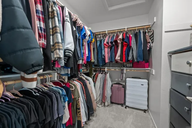 a view of walk in closet with clothes