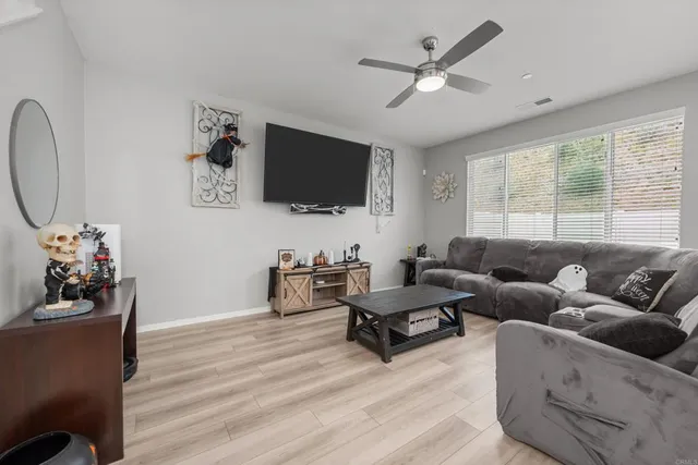 a living room with furniture a flat screen tv and a large window