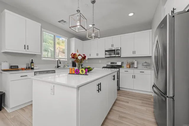 a kitchen with cabinets appliances a sink and a window