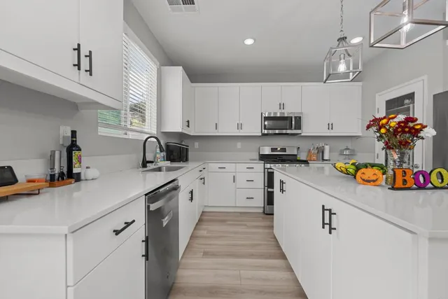 a kitchen with kitchen island granite countertop lots of counter top space and wooden floor