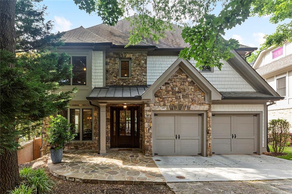a view of a house with a small yard plants and large tree