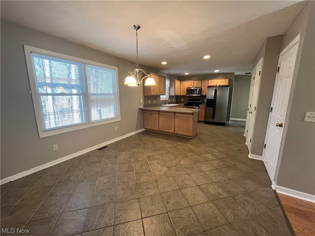 2819 Best Road Cambridge, OH 43725 - Photo 5 of 33 Kitchen featuring pendant lighting, a notable chandelier, stainless steel appliances, backsplash, and sink