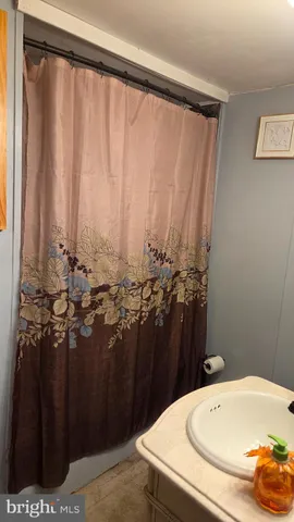 a bathroom with a granite countertop sink and a bathtub