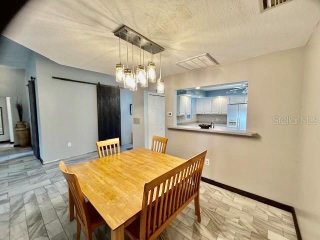 7971 Waupegan Avenue Sebastian, FL 32958 - Photo 11 of 26 a kitchen with stainless steel appliances kitchen island granite countertop a table chairs in it and wooden floor