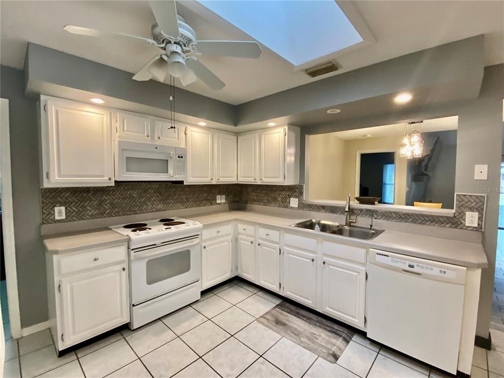 7971 Waupegan Avenue Sebastian, FL 32958 - Photo 5 of 26 a kitchen with white cabinets appliances and a sink