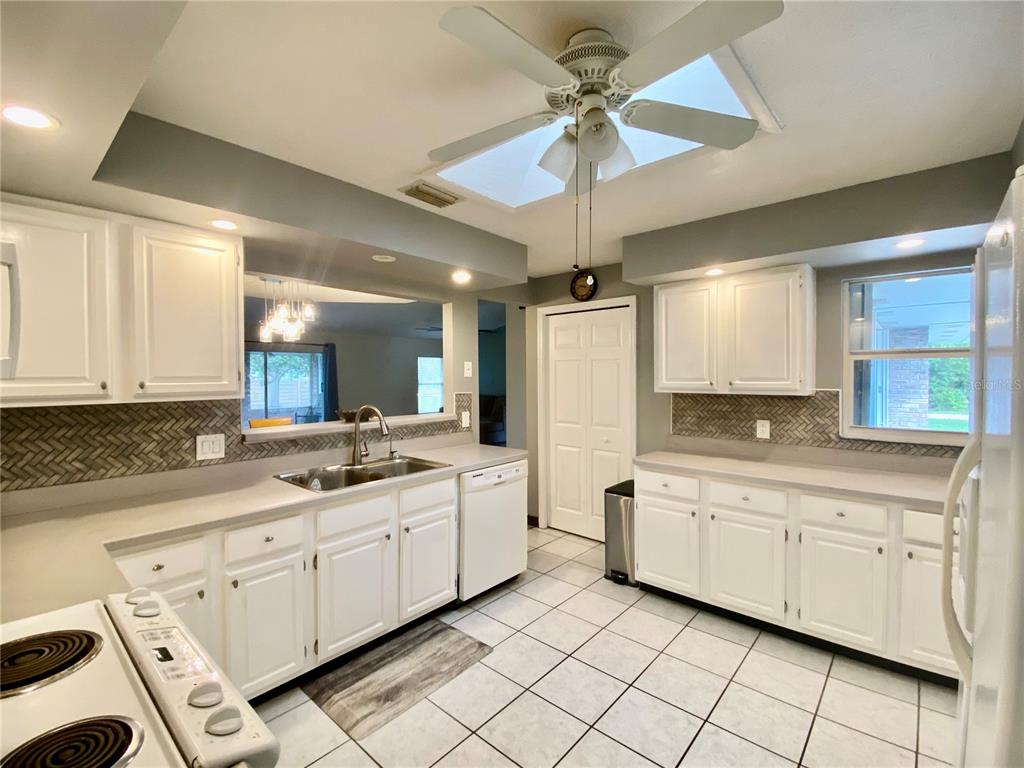 7971 Waupegan Avenue Sebastian, FL 32958 - Photo 6 of 26 a kitchen with white cabinets a sink appliances and cabinets