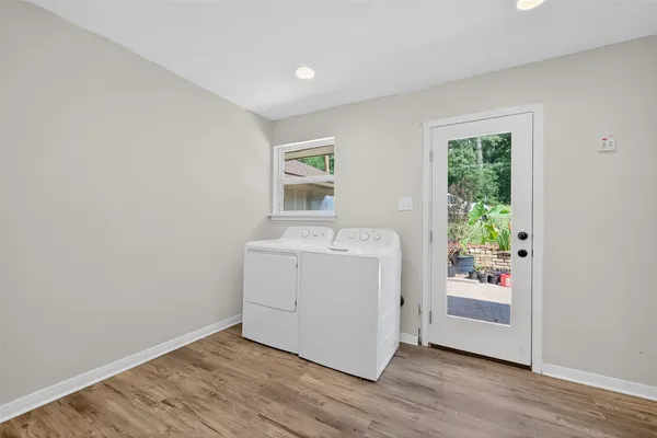 a utility room with wooden floor washer and dryer